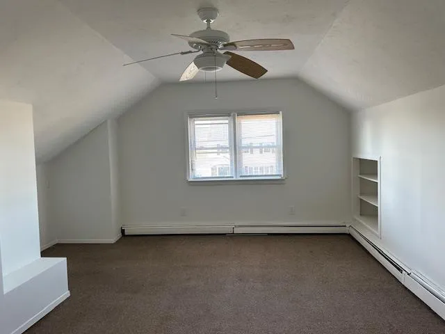 an empty room with a window and a ceiling fan