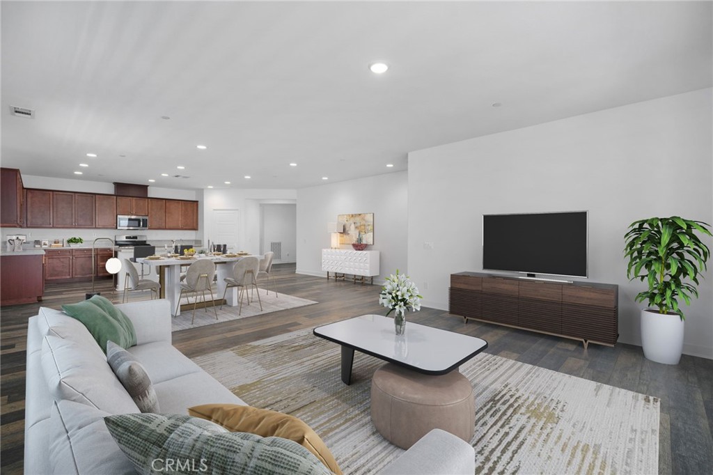a living room with furniture kitchen view and a potted plant