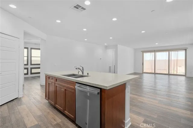 a kitchen with a sink and wooden floor