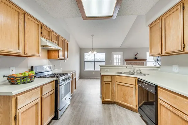 a kitchen with stainless steel appliances granite countertop sink stove top oven and cabinets