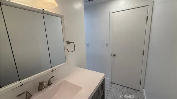 a bathroom with a sink vanity and mirror
