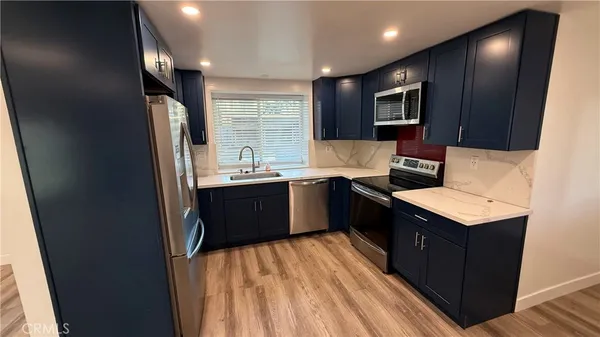 a view of a hallway with wooden floor and a living room