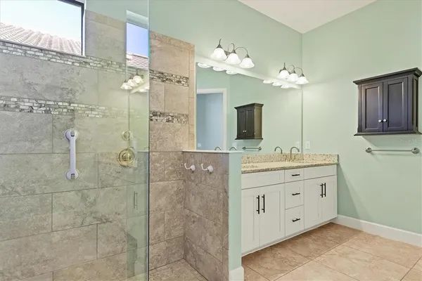a bathroom with a double vanity sink mirror and shower