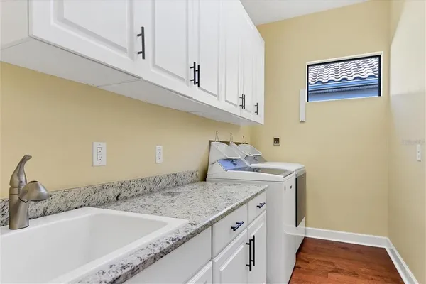 a bathroom with a granite countertop sink and white cabinets