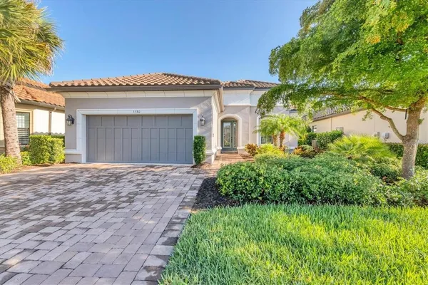 a front view of a house with a garden and plants