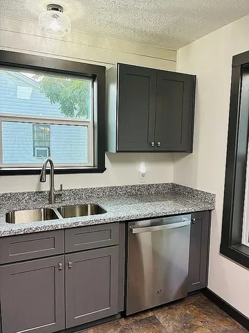 a kitchen with granite countertop a sink and a wooden cabinets