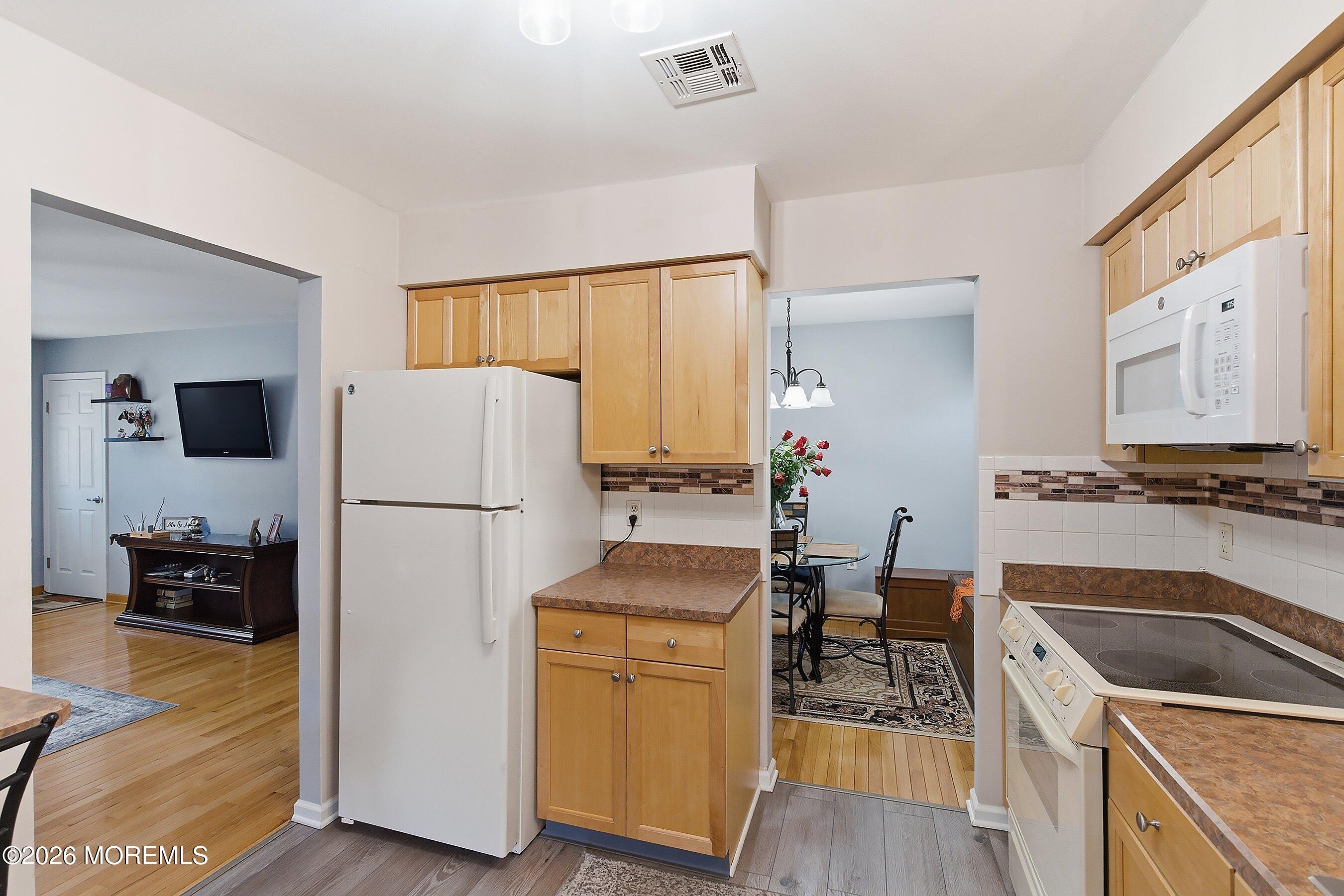 8 Hummingbird Lane Whiting, NJ 08759 - Photo 8 of 41 a kitchen with a refrigerator a stove top oven a counter space and wooden floor