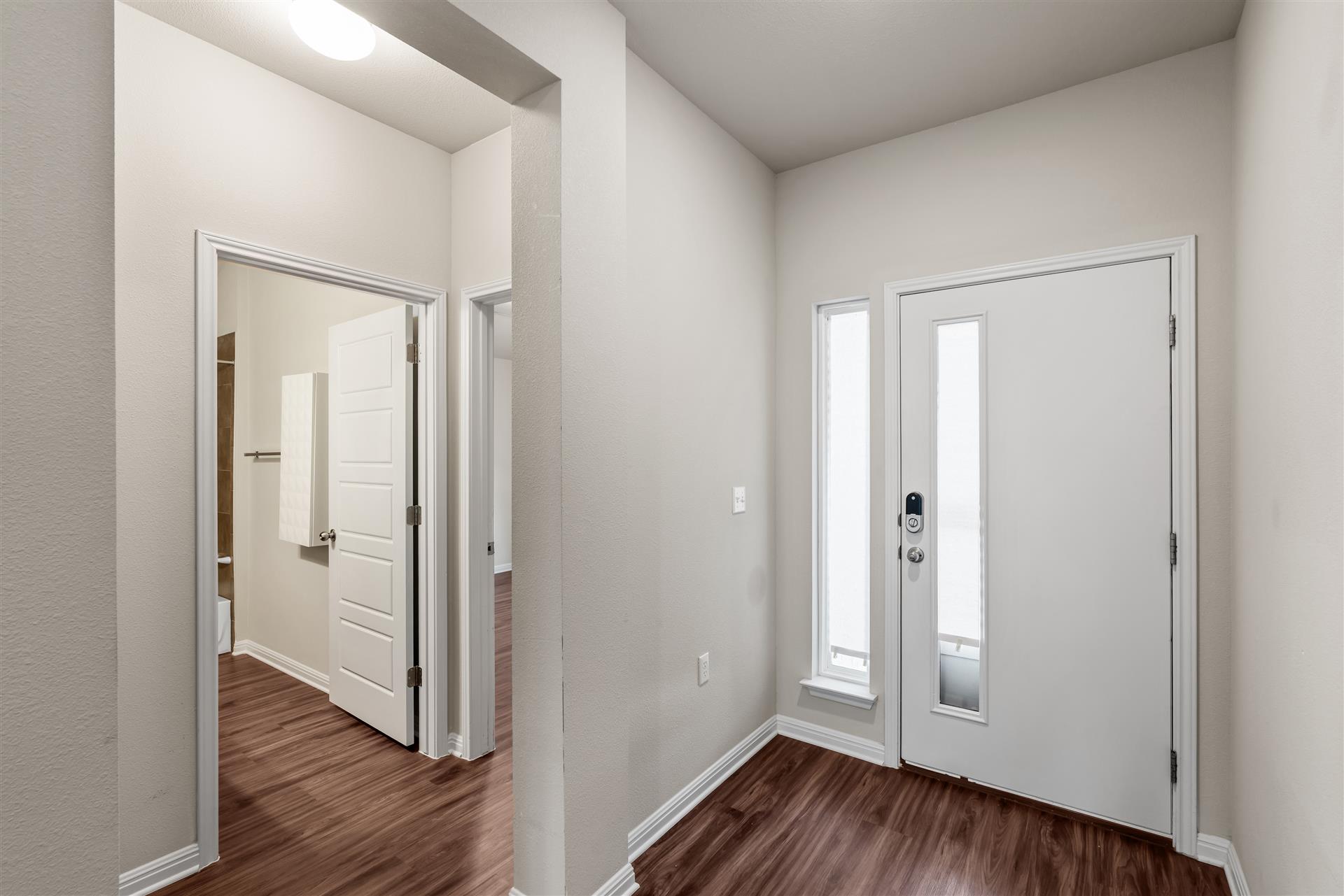 16512 Enamorado Road Manor, TX 78653 - Photo 16 of 31 Enter into a bright hallway, featuring durable wood flooring and modern white trim.