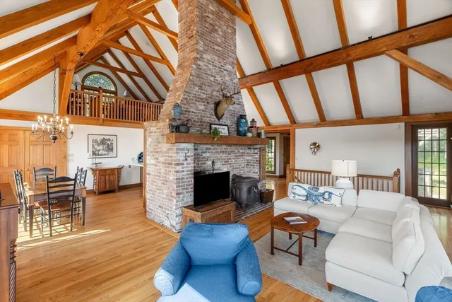 a living room with furniture a fireplace and wooden floor
