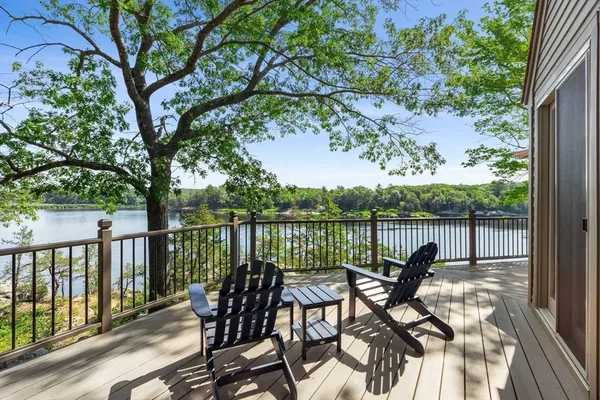 a view of a balcony with chairs and wooden fence