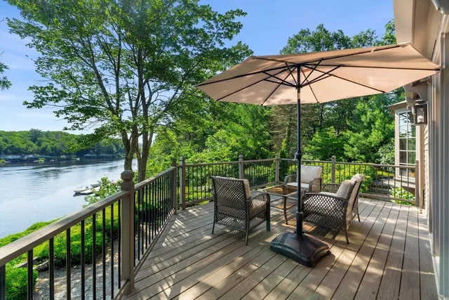 a view of deck with furniture and umbrella