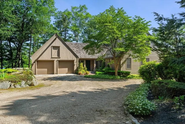 a front view of a house with a yard and potted plants