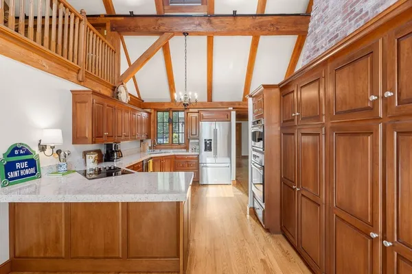 a kitchen with stainless steel appliances granite countertop a refrigerator a sink and wooden cabinets