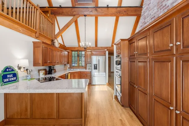 a kitchen with stainless steel appliances granite countertop a refrigerator a sink and wooden cabinets