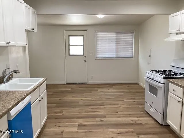 a kitchen with stainless steel appliances granite countertop a sink stove and cabinets