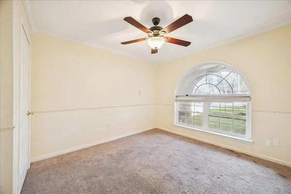an empty room with windows and fan