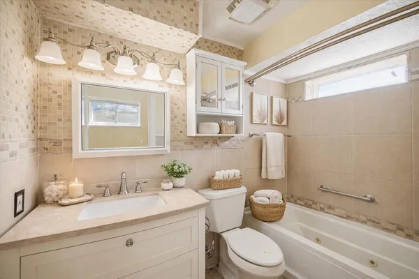 a bathroom with a granite countertop toilet sink and mirror