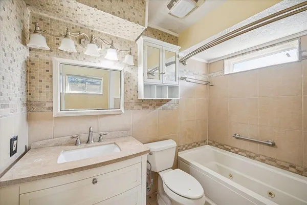 a bathroom with a granite countertop sink toilet a mirror and shower