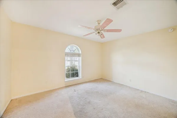 an empty room with windows and fan