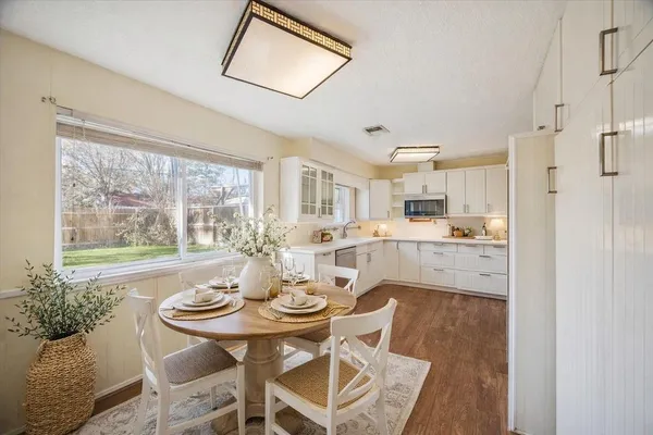 a kitchen with a table chairs refrigerator and cabinets