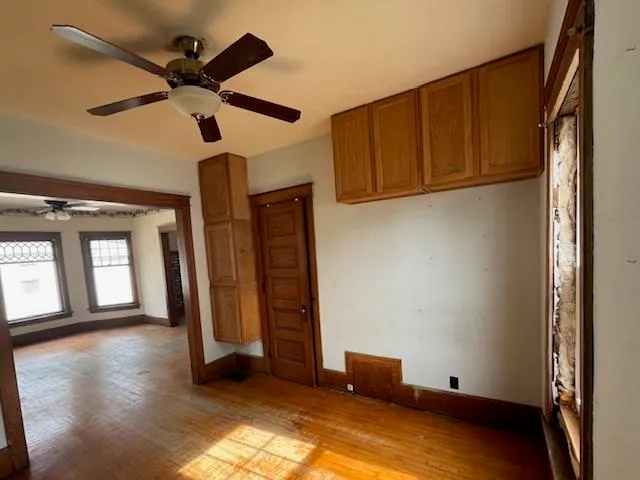 a view of a livingroom with wooden floor and a ceiling fan