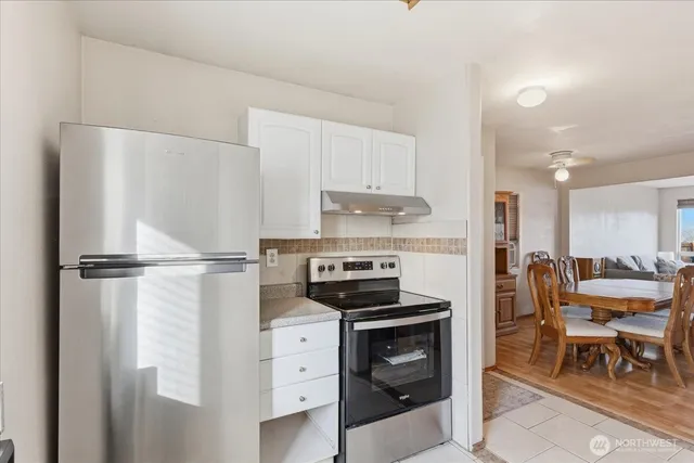 a kitchen with a refrigerator a table and chairs