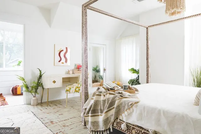 a bedroom with a bed and window with the potted plants