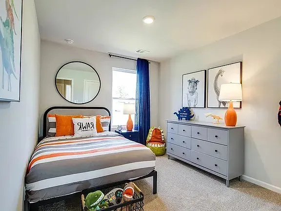 a bedroom with a bed a mirror and dresser