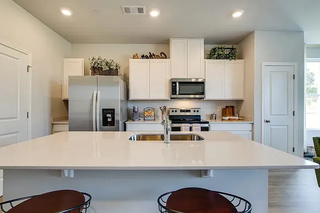 a kitchen with stainless steel appliances a refrigerator and a stove top oven