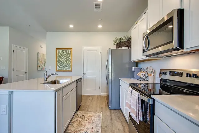 a kitchen with stainless steel appliances granite countertop a sink stove and refrigerator