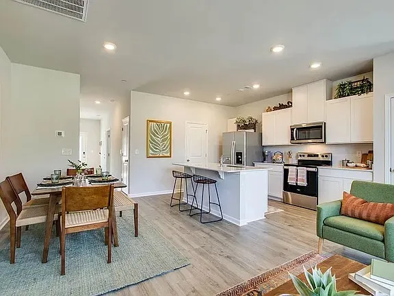 a living room with furniture and kitchen view