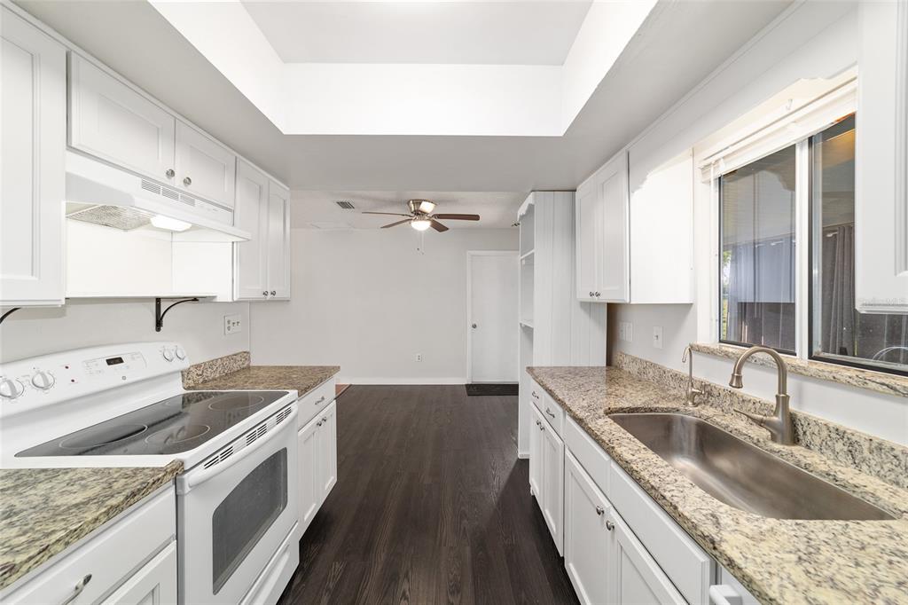 8329 Southwest 105th Place Ocala, FL 34481 - Photo 14 of 39 a kitchen that has a sink a stove and a wooden floor