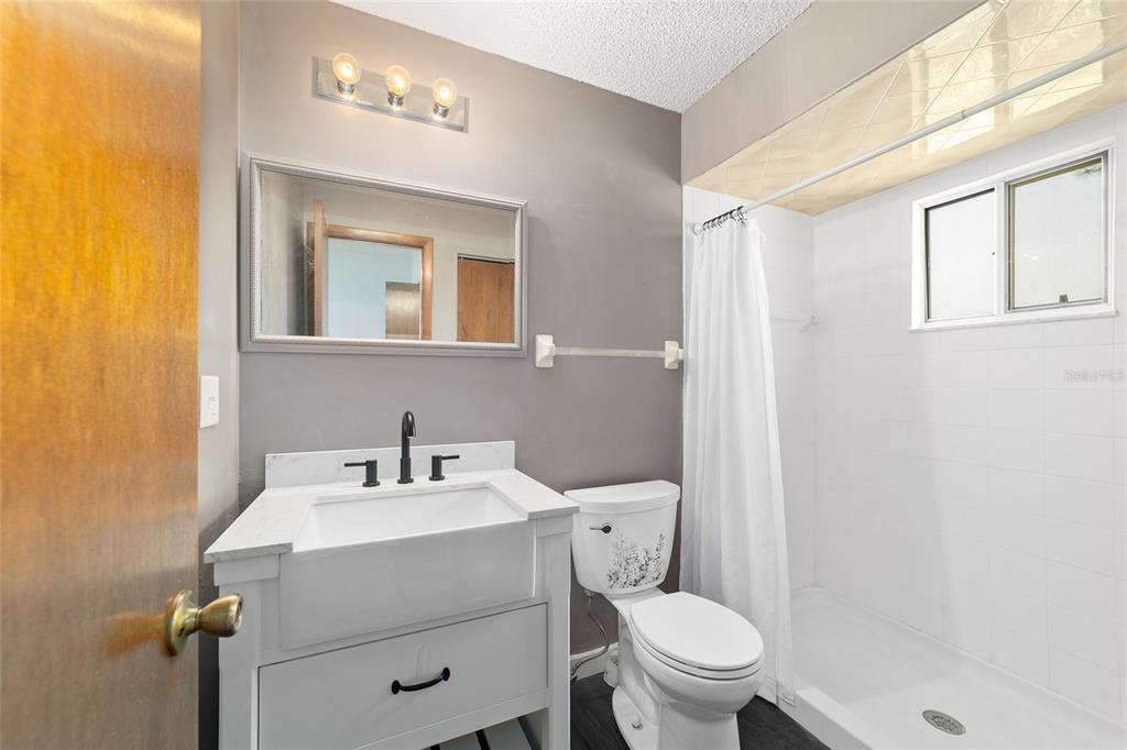 8329 Southwest 105th Place Ocala, FL 34481 - Photo 19 of 39 a bathroom with a toilet a sink a mirror and a shower