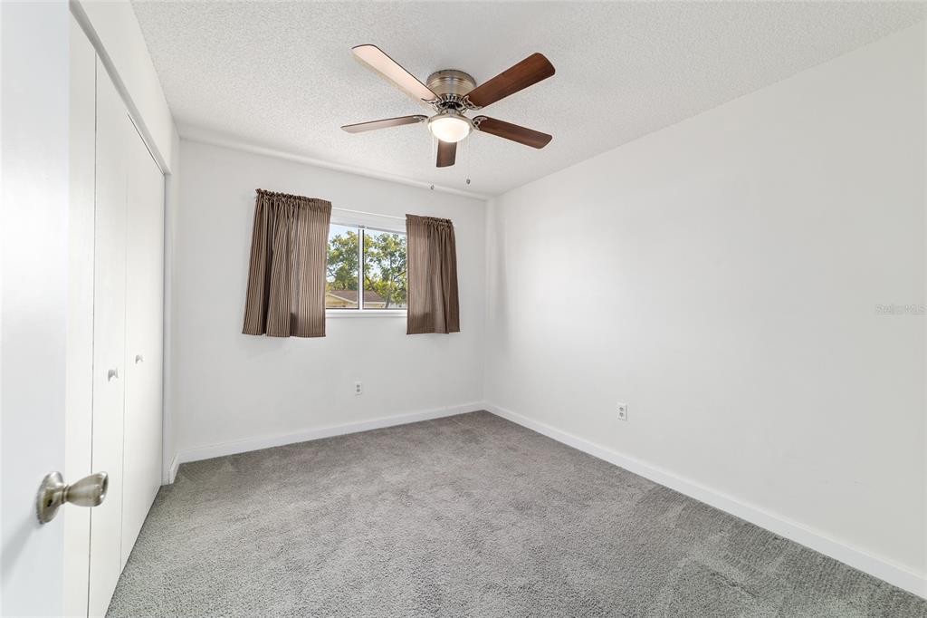 8329 Southwest 105th Place Ocala, FL 34481 - Photo 20 of 39 an empty room with ceiling fan and window