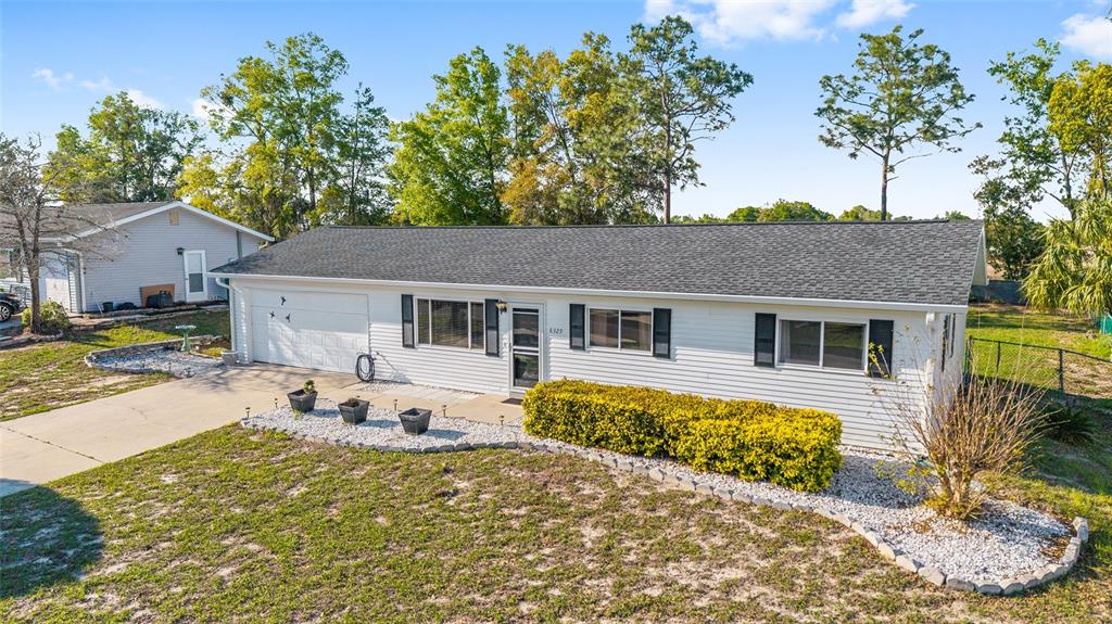 8329 Southwest 105th Place Ocala, FL 34481 - Photo 24 of 39 a front view of a house with a yard outdoor seating and garage