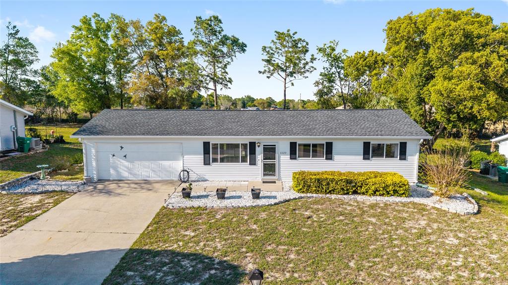 8329 Southwest 105th Place Ocala, FL 34481 - Photo 25 of 39 a front view of a house with a yard and garage