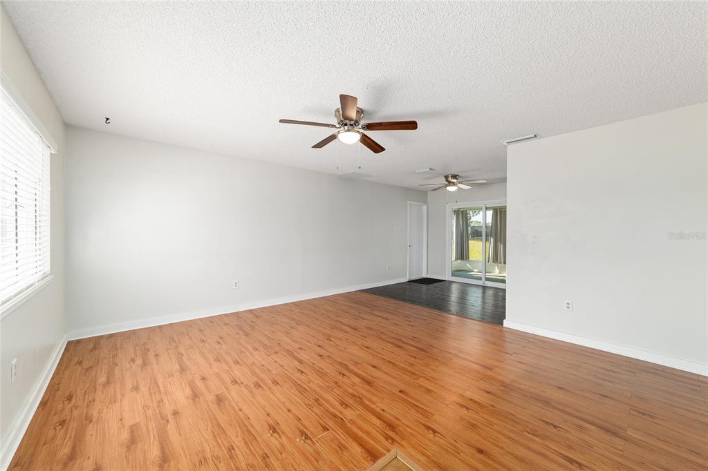8329 Southwest 105th Place Ocala, FL 34481 - Photo 5 of 39 wooden floor in an empty room with a window