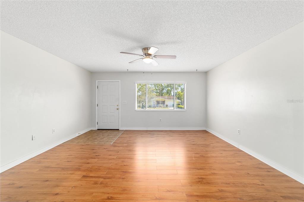 8329 Southwest 105th Place Ocala, FL 34481 - Photo 7 of 39 an empty room with wooden floor and windows