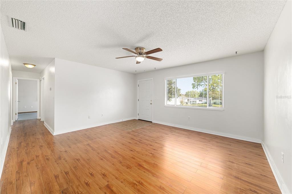 8329 Southwest 105th Place Ocala, FL 34481 - Photo 8 of 39 wooden floor in an empty room with a window