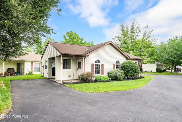 a view of a house with a yard and potted plants