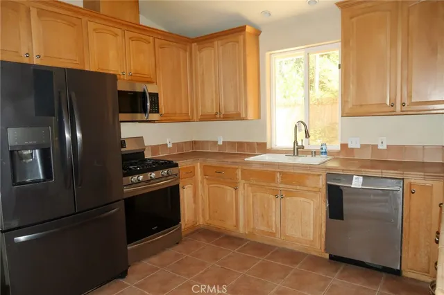 a kitchen with stainless steel appliances granite countertop a refrigerator sink and stove