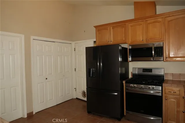 a kitchen with stainless steel appliances a refrigerator and a stove top oven