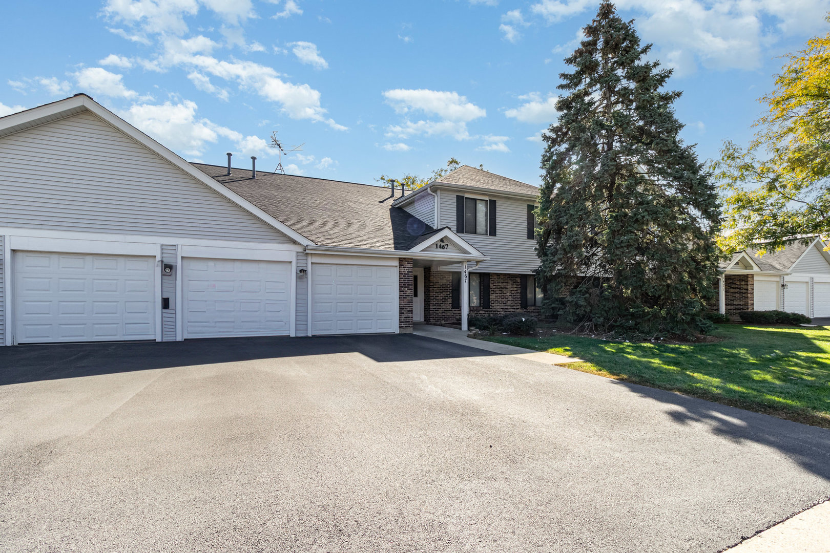 1467 Fairlane Drive, Unit 1B Schaumburg, IL 60193 - Photo 2 of 17 a front view of a house with a yard and garage
