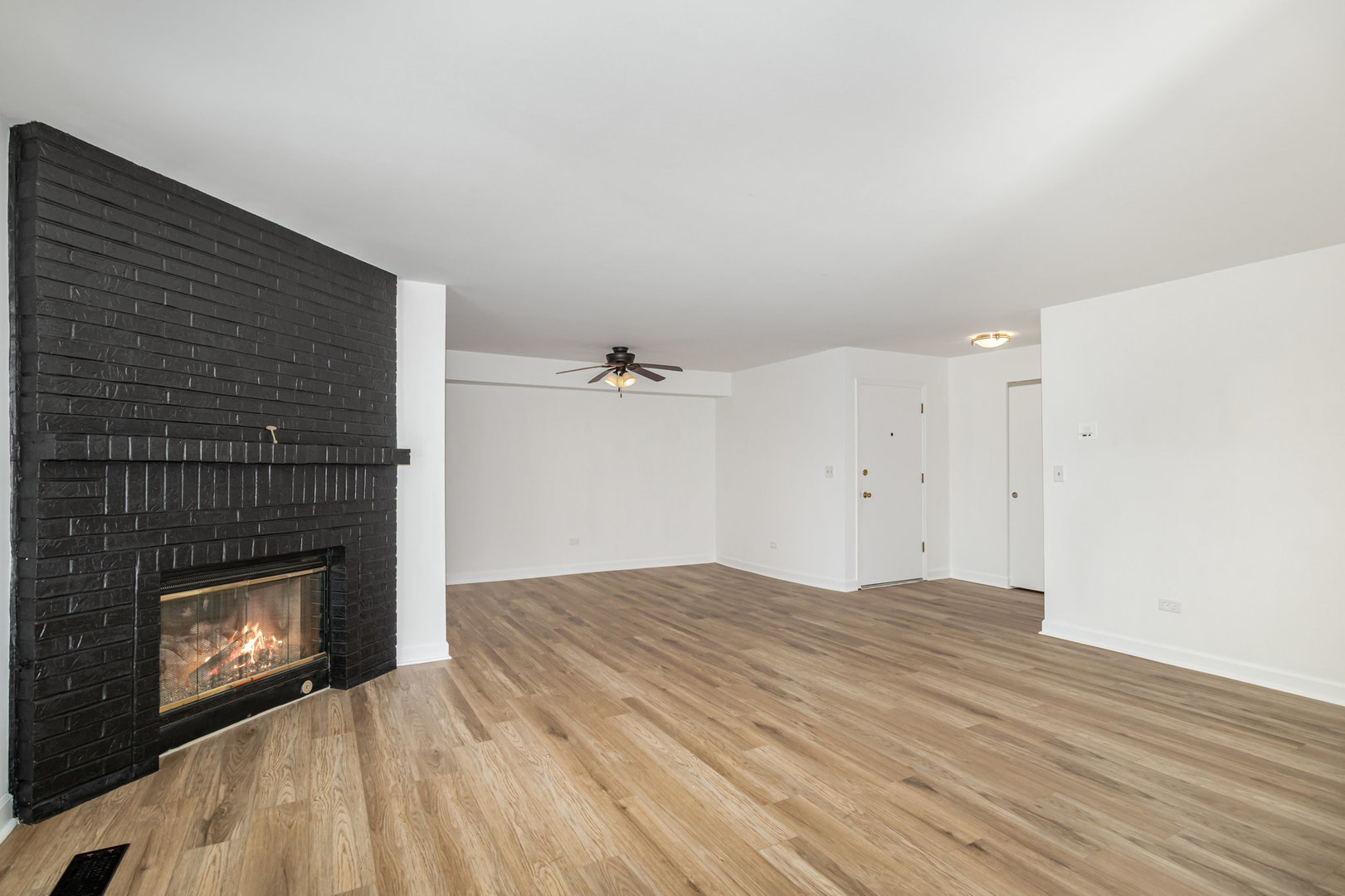 1467 Fairlane Drive, Unit 1B Schaumburg, IL 60193 - Photo 4 of 17 a view of empty room with wooden floor and fireplace
