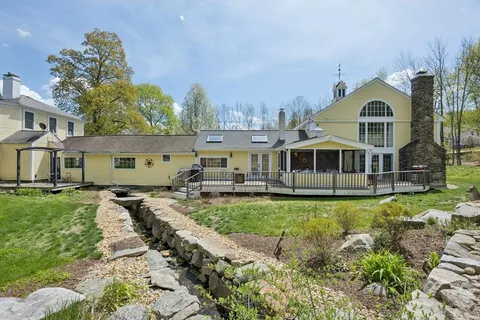 a front view of house with yard and trees in the background