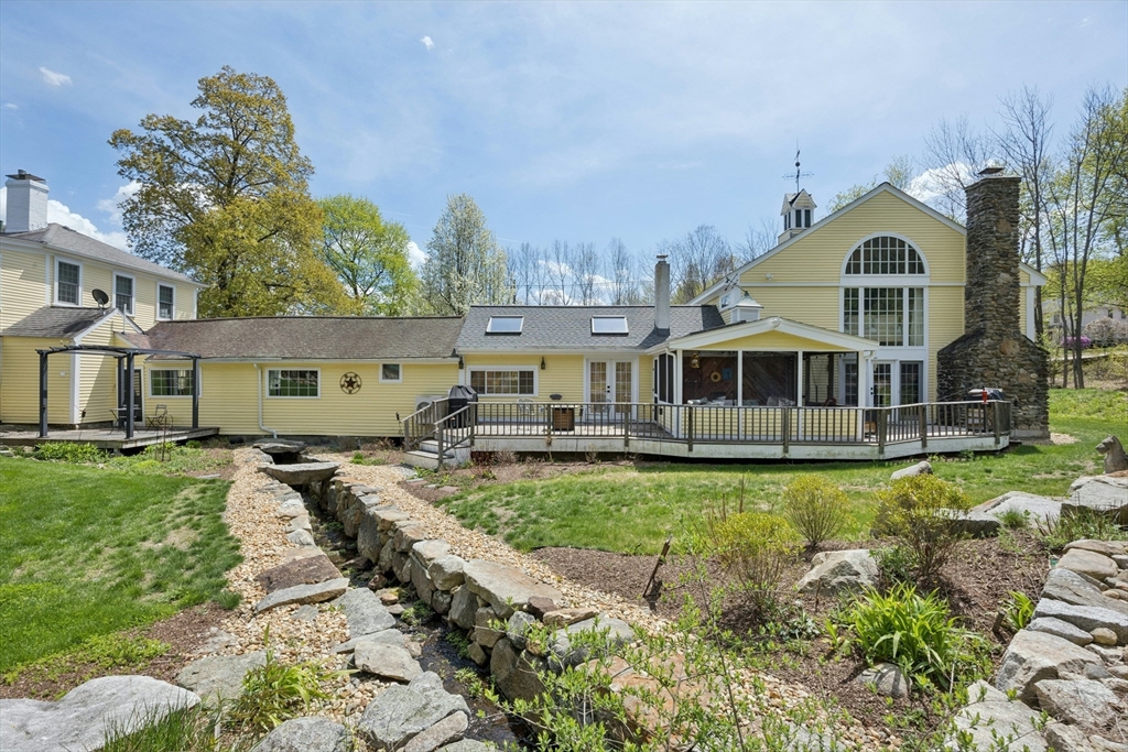 100 Main Street Ashburnham, MA 01430 - Photo 2 of 42 a front view of house with yard and trees in the background