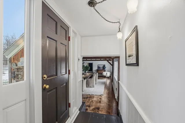 a view of a hallway with a livingroom and furniture