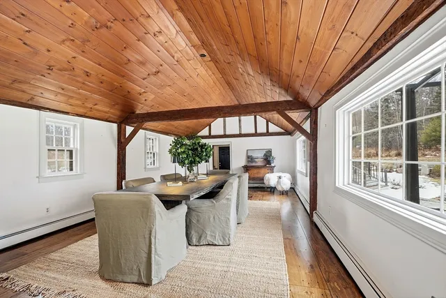 a dining room with furniture and a large window