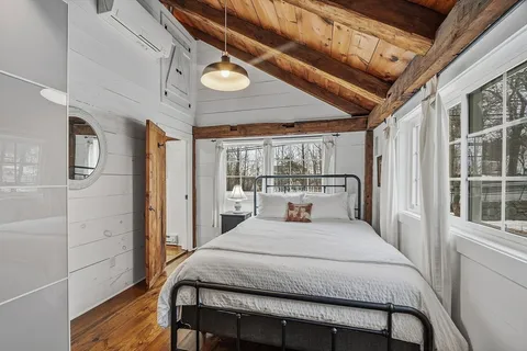 a bedroom with a bed mirror and a large window