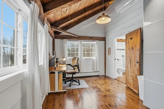 a view of a livingroom with workspace and a window